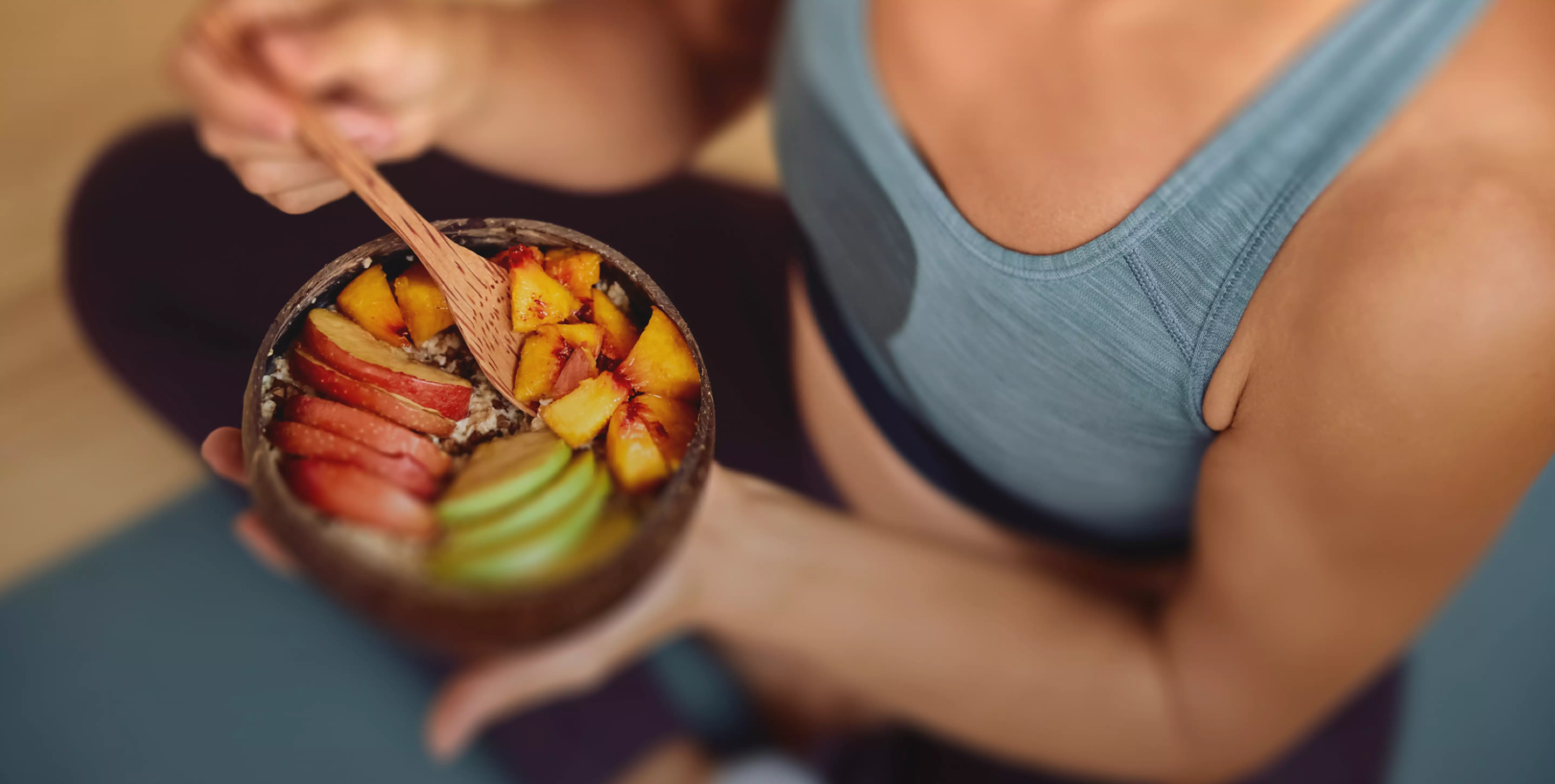 Close-up of a woman holding on to a smoothie bowl, representing healthy eating