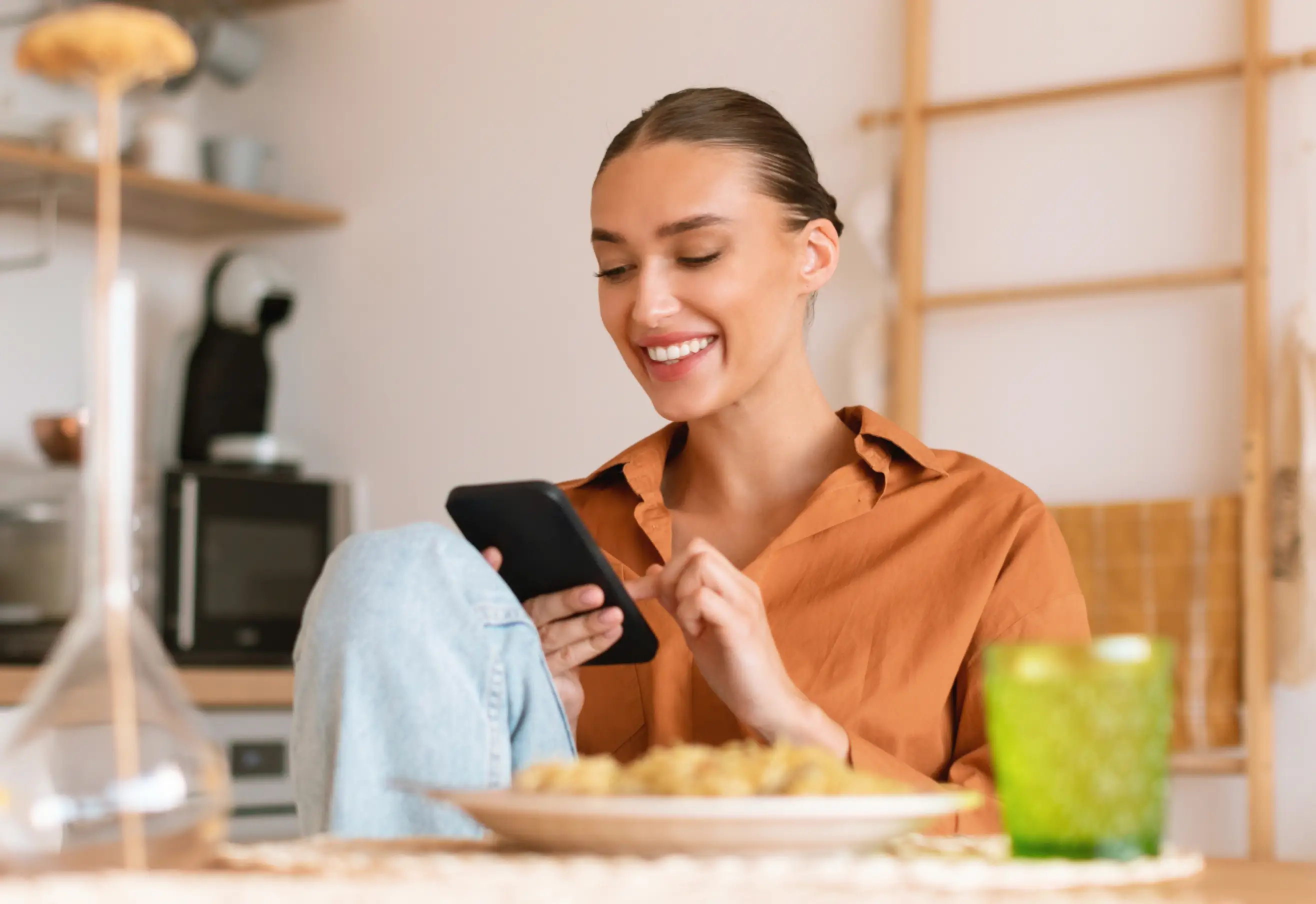 Close up of a woman smiling and using her phone to track food and calorie intake on the go