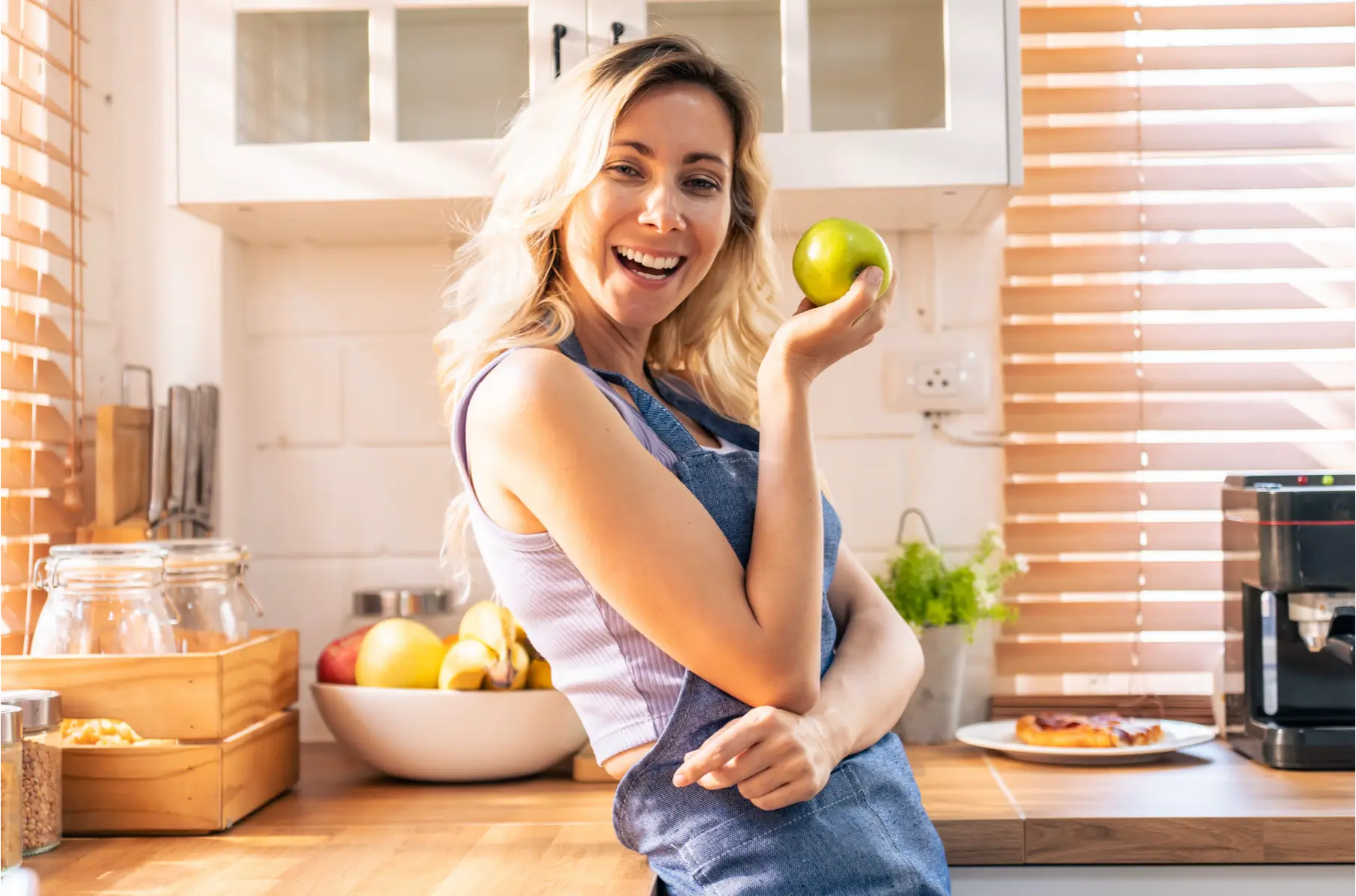 Woman smiling with an apple in her hand, representing the ease of Eato’s quick log feature