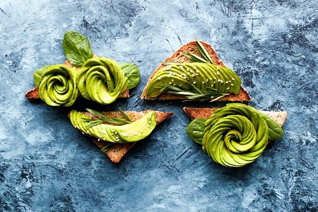 Creamy mashed avocado spread on gluten-free toast, topped with herbs, a healthy and filling breakfast choice.