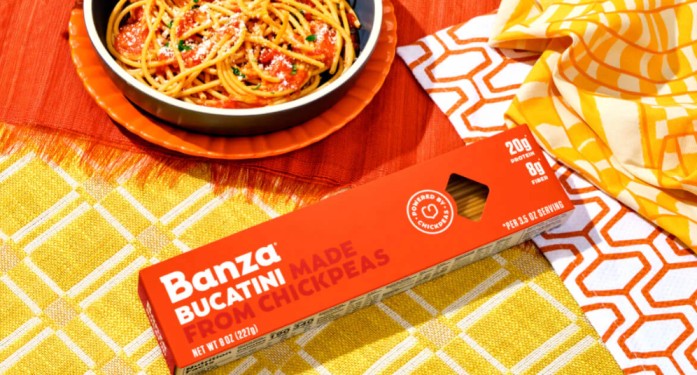 Banza Bucatini made from chickpeas packaging beside a plate of pasta, a high protein gluten free low carb pasta alternative.