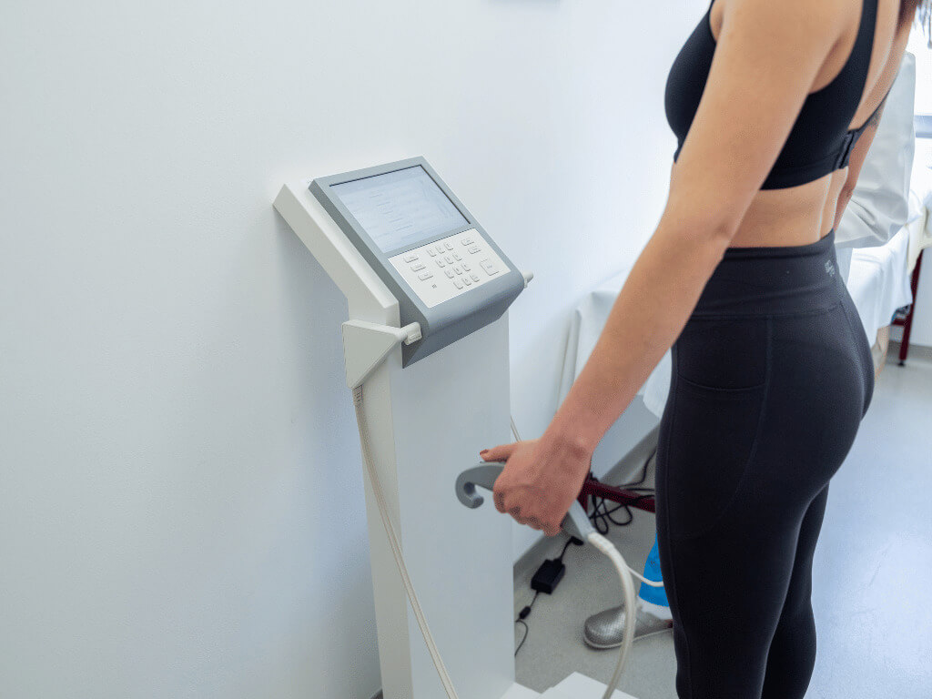 Woman measuring her body composition with body composition analysis