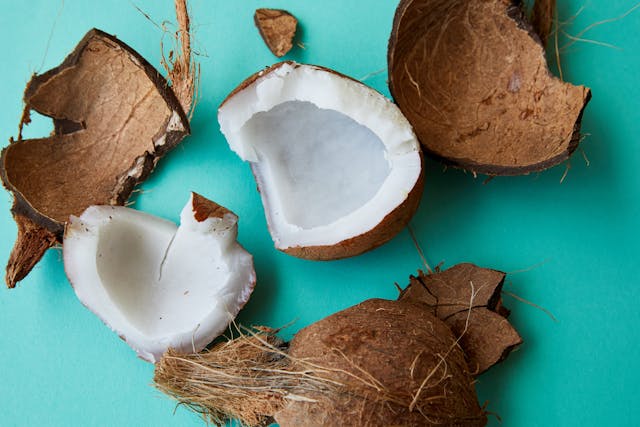 Bowl of unsweetened coconut chips on a table, a crunchy gluten-free snack rich in healthy fats and natural sweetness.
