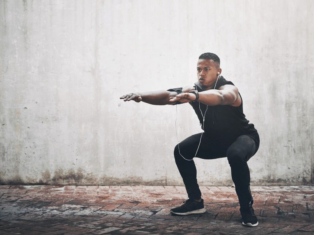 A man performing a cossack squat outdoors, strengthening inner thigh muscles and improving lower body flexibility.