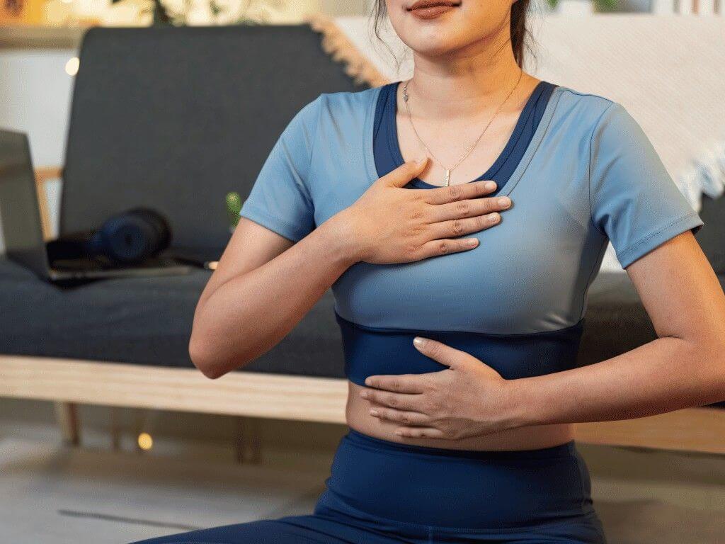 Woman practicing deep breathing to lower cortisol naturally and reduce stress levels for improved relaxation