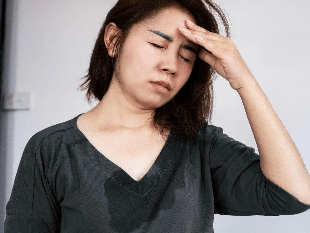 Woman feeling dizzy shows possible downsides of intermittent fasting like fatigue and low blood sugar.