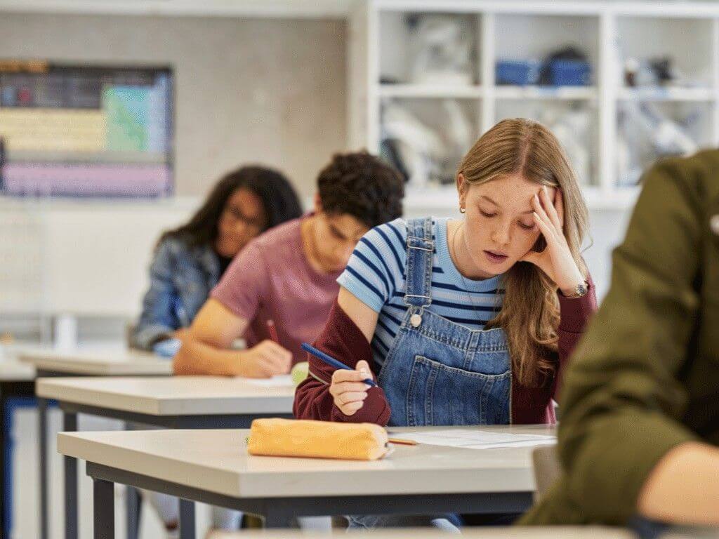 Student feeling stressed during exam, showing high cortisol levels linked to stress response and adrenal activation