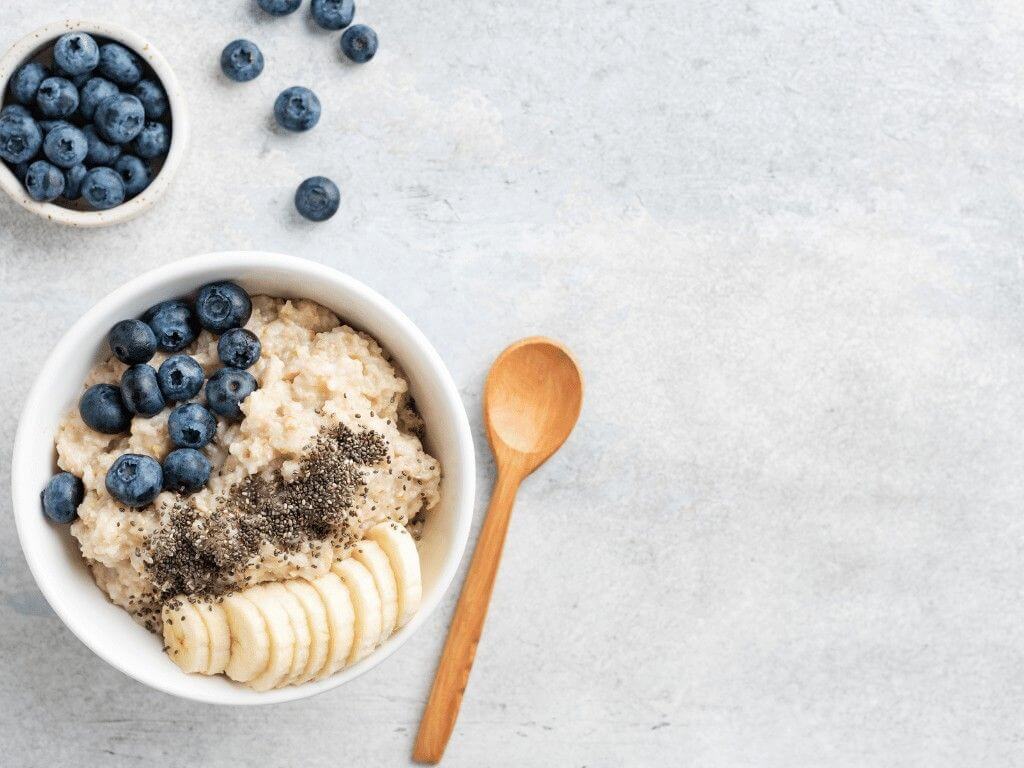 Low FODMAP banana and blueberry oatmeal topped with chia seeds in a bowl.
