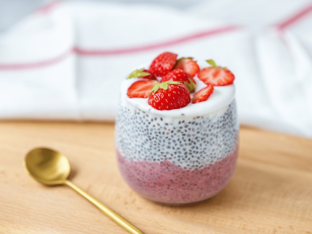 Low FODMAP Greek yogurt parfait with strawberries and chia seeds in a glass.
