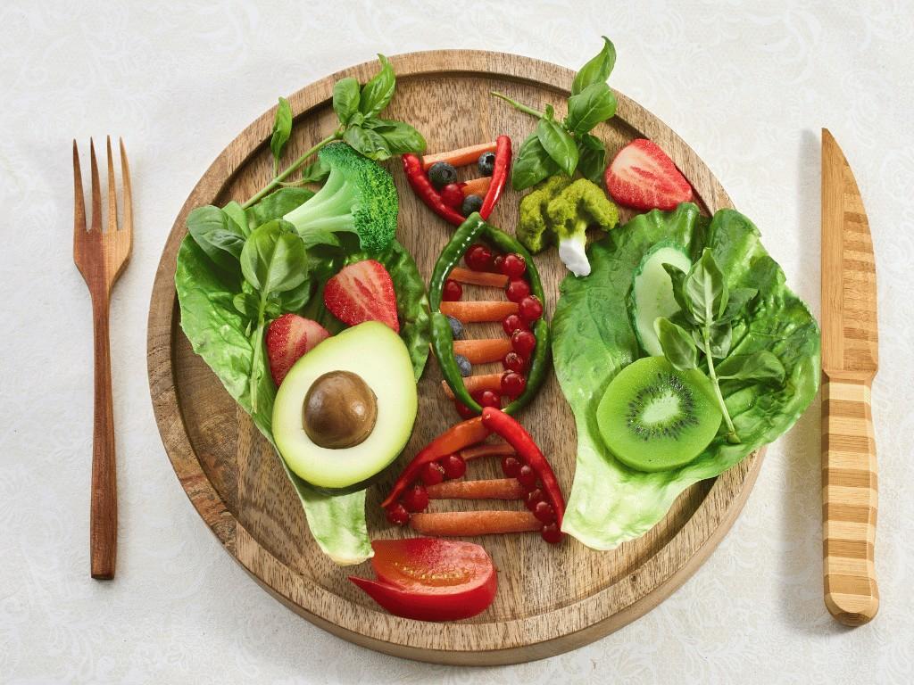 Colorful fruits and vegetables arranged as a DNA strand on a wooden plate.