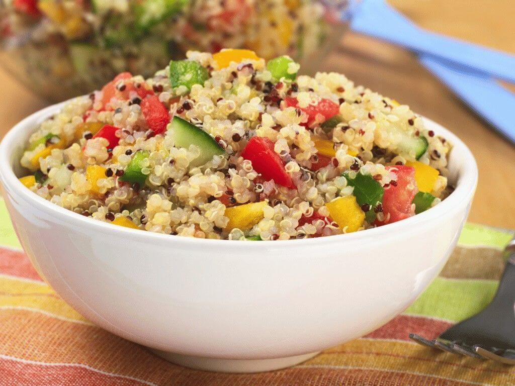 A bowl of quinoa salad with cucumber, peppers, and tomatoes, a healthy Mediterranean meal prep recipe for lunch or dinner.