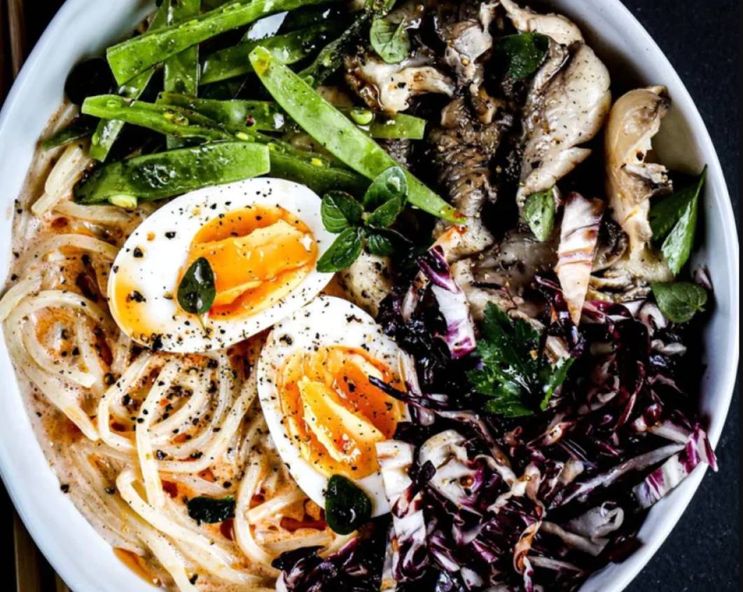 Bowl of Miracle Noodle shirataki noodles topped with eggs, mushrooms, and greens, a low carb keto friendly pasta alternative.