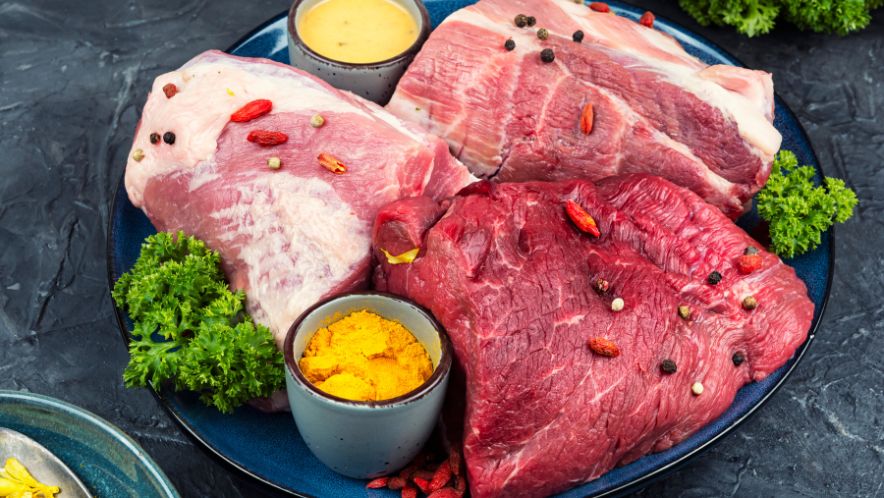 Different kinds of raw meat that can be eaten on the paleo diet laid out on a plate.