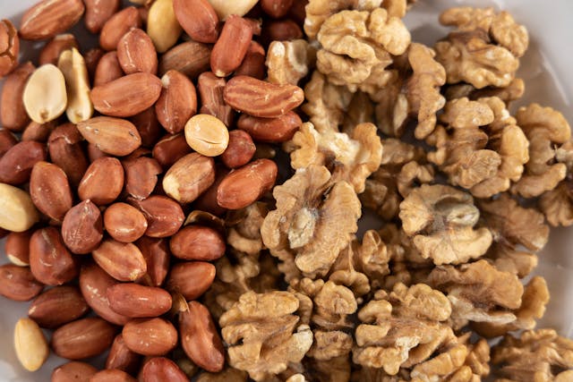 Walnuts and a glass jar of oil are healthy fat sources that support vitamin absorption and energy production.
