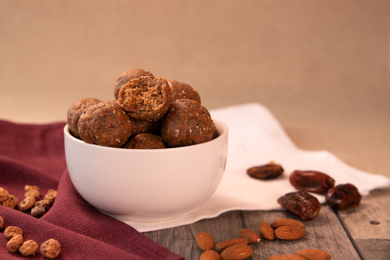 Bowl of homemade energy balls made with dates, nuts, and cocoa, a gluten-free bite-sized snack packed with nutrients.