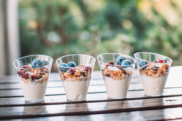 Yogurt parfait in a jar topped with berries and granola, a creamy gluten-free snack perfect for school or home.
