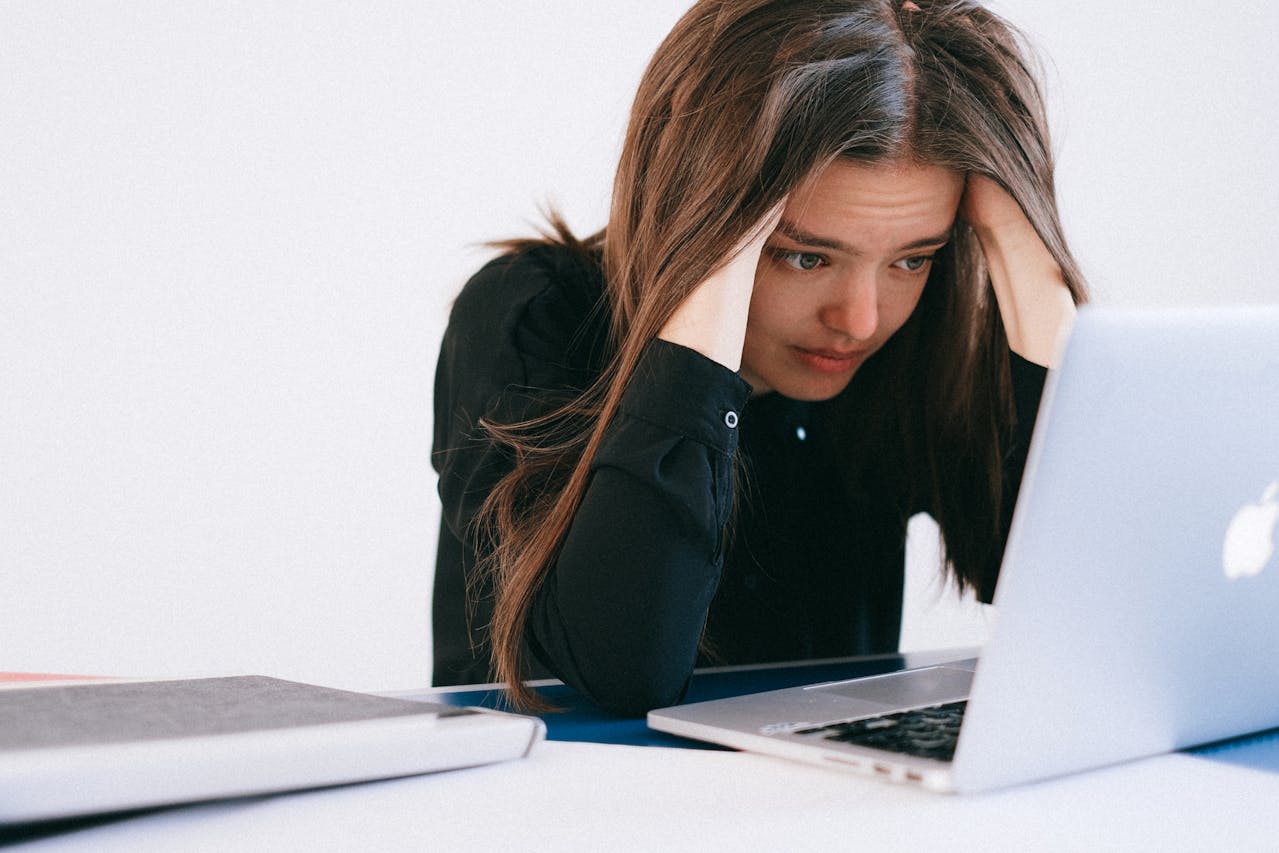 Woman sitting at a desk stressed in front of laptop, emotional distress and overeating.