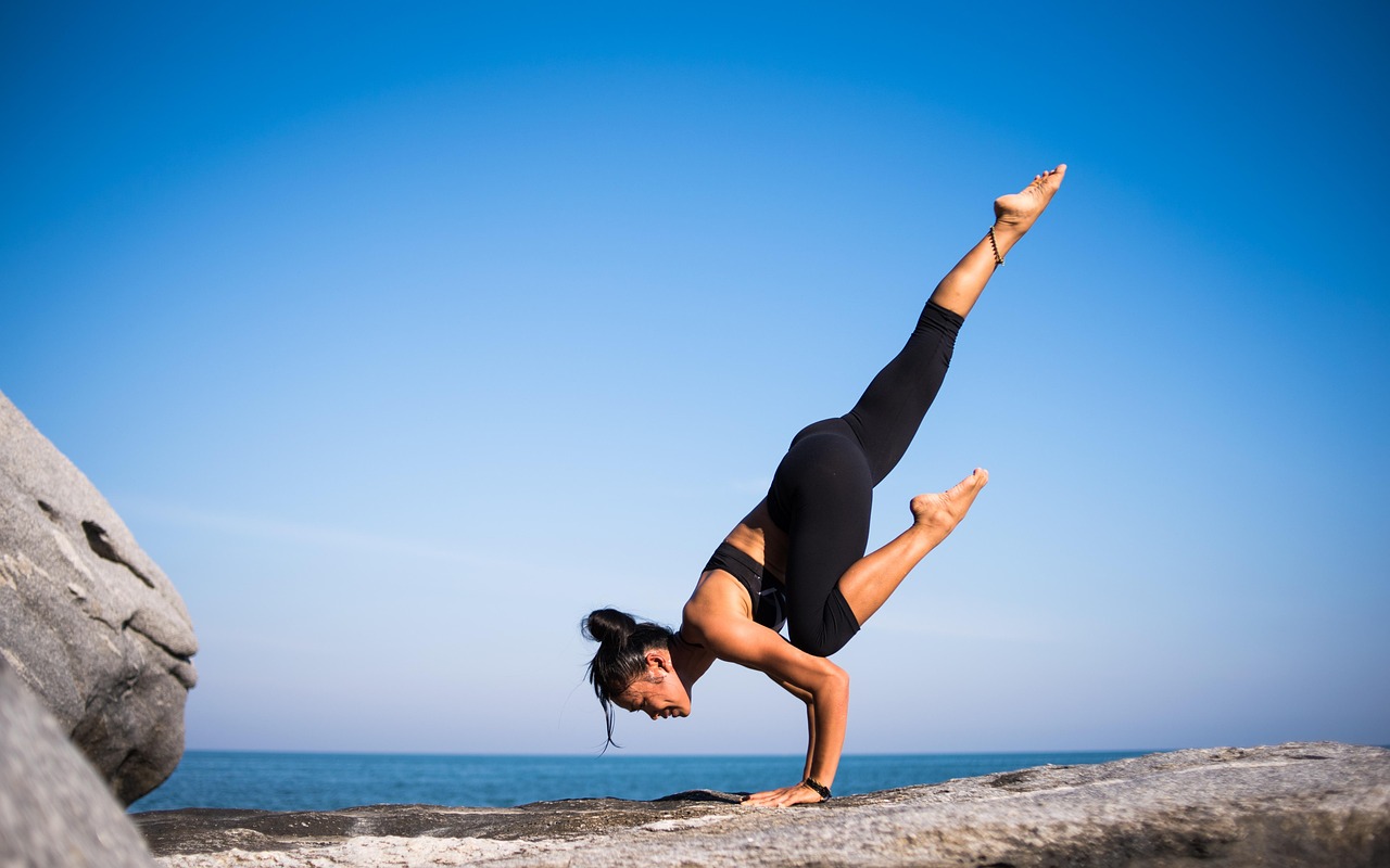 Woman practicing yoga outdoors for mindfulness to reduce stress eating habits.