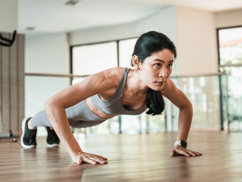 Woman doing a push up in plank position for building upper body strength and muscle endurance