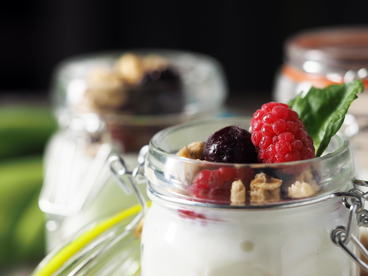 Yogurt parfait in a jar topped with berries and granola, a creamy gluten-free snack perfect for school or home.