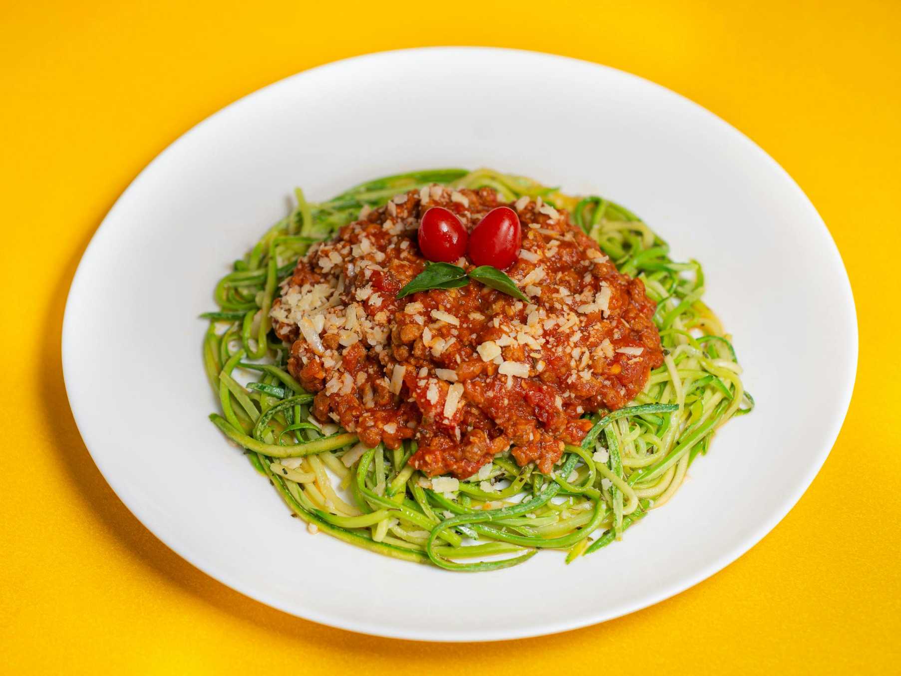 Zucchini noodles topped with tomato sauce and parmesan, a low carb pasta alternative perfect for keto and gluten free diets.