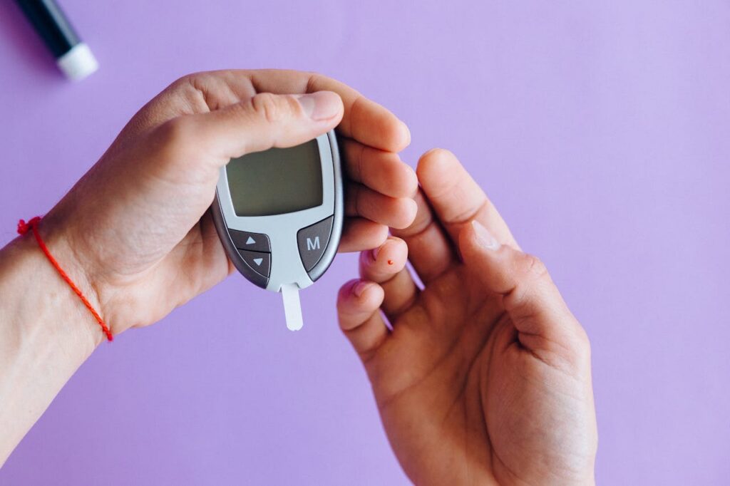 Person using a blood glucose meter to check blood sugar levels linked to hunger, stress hormones, and irritability.