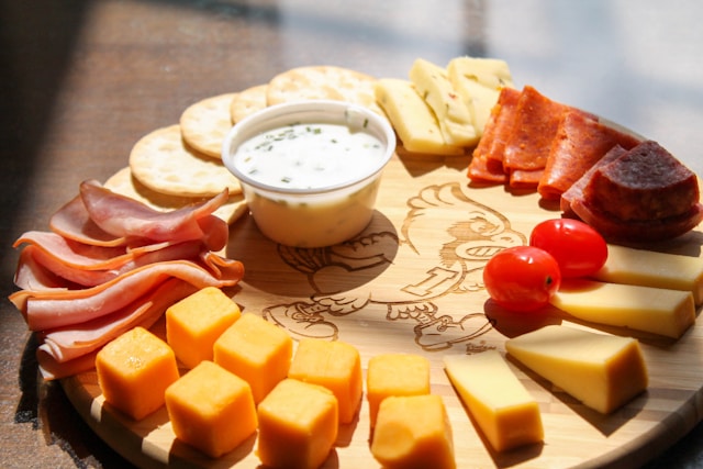 Charcuterie board with cheeses, meats, nuts, and dip are common high fat food choices on the Modified Atkins Diet.