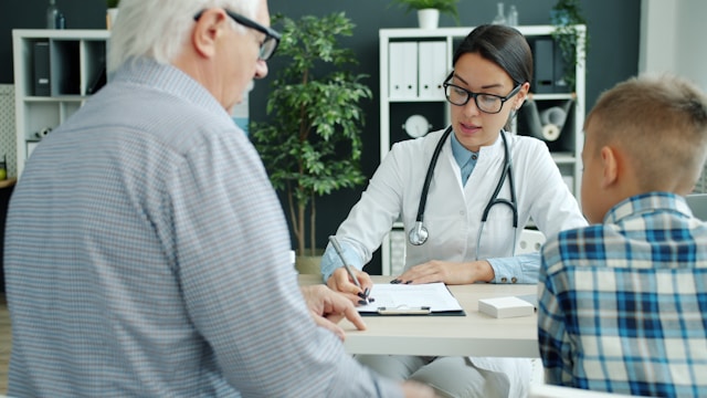 A doctor speaking with an older man and a child during a dietary therapy consultation focused on nutrition guidance and health improvement.