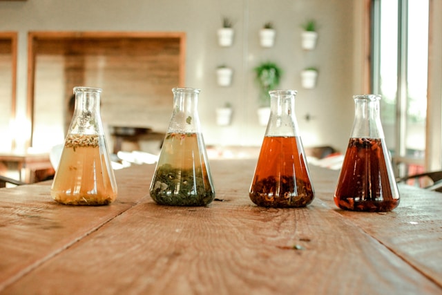 Flasks of green tea and black tea steeping at different oxidation levels.