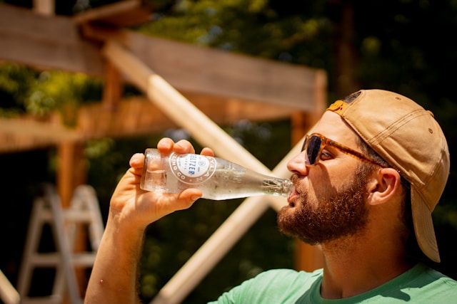 Man drinking bottled water outdoors as the Modified Atkins Diet encourages free fluid intake to prevent discomfort.
