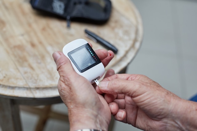 Older adult checking blood glucose with a glucometer, as diabetes mellitus as a risk factor for SIBO