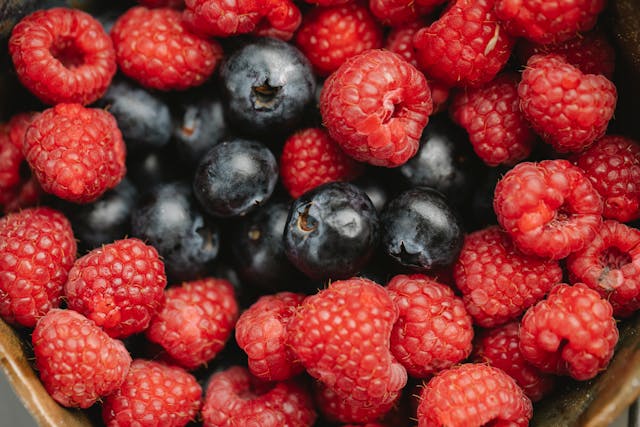 Fresh raspberries and blueberries rich in antioxidants that help reduce oxidative stress and inflammation