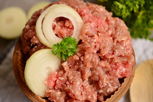 Bowl of raw minced meat topped with onions that can cause foodborne infections when eaten undercooked.