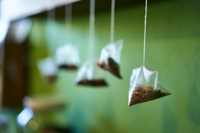 Tea bags hanging in a row for caffeine intake, thermogenesis, and differences in fat burning responses. Does green tea help with weight loss?