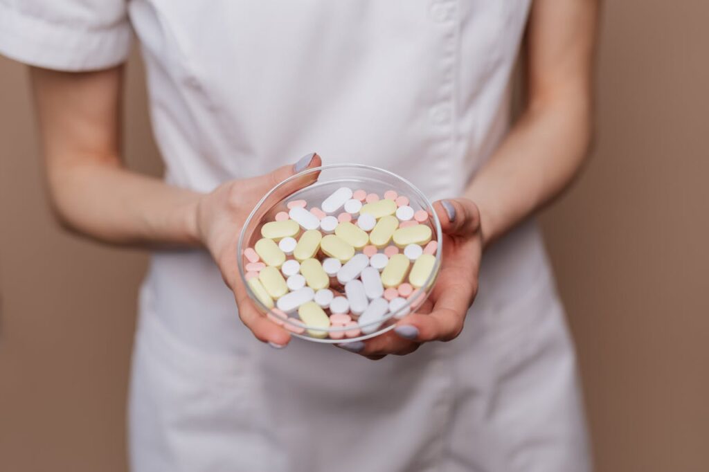 Healthcare worker holding a bowl of assorted pills, used in discussion of switching medications to reduce Lexapro weight gain