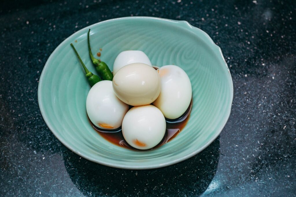 Bowl of hard boiled eggs in soy sauce with chilies, egg diet.